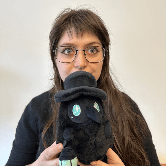 Person holding Squishable Plague Doctor Void plush with teal eyes and lantern