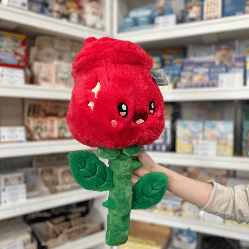 Squishable Red Rose plush toy angled view held in hand in a shop