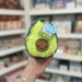 Squishable Snacker Avocado plush toy held in hand, front view