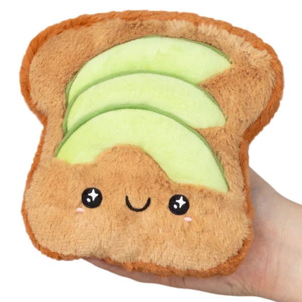Front view of the Squishable Snacker Avocado Toast plushie showing a smiling face with embroidered avocado slices.