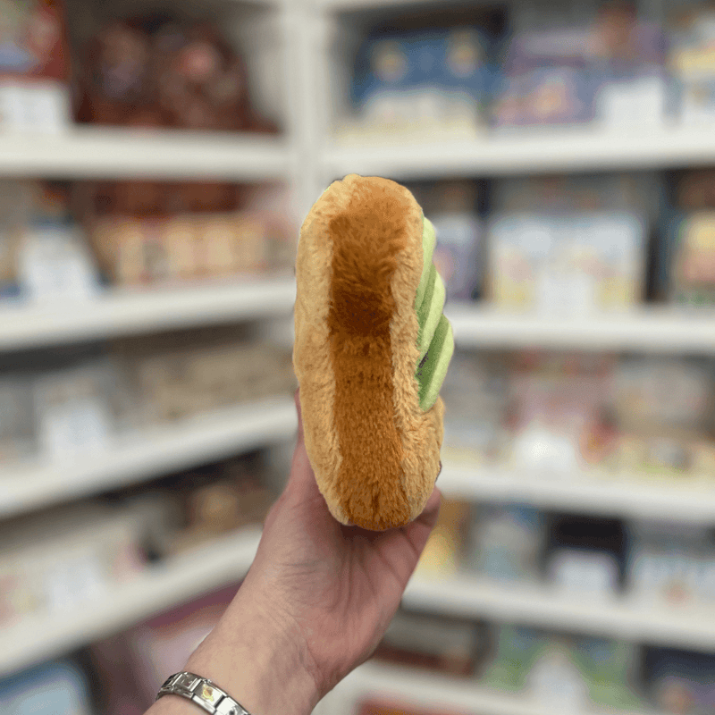 Squishable Snacker Avocado Toast plush toy held in hand, side view