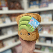 Squishable Snacker Avocado Toast plush toy held in hand with tag visible