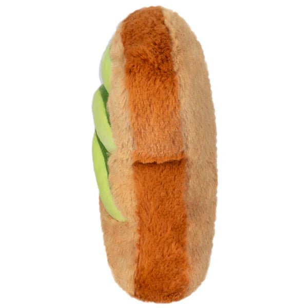 Side view of the Squishable Snacker Avocado Toast plushie highlighting plush green avocado slices and thick toast shape.