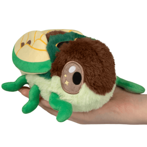 Front view of the Squishable Snacker Cicada plush toy with green legs and soft wings