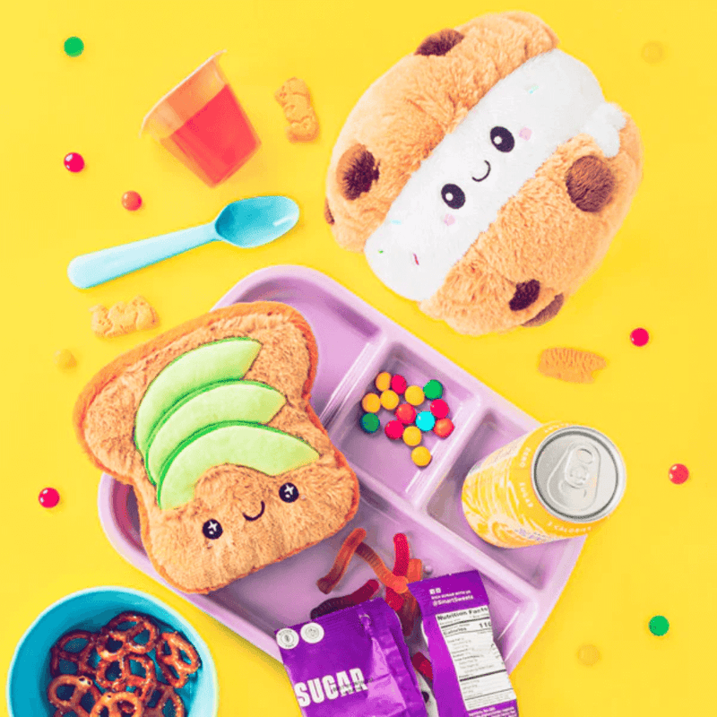 Squishable Snacker Cookie Ice Cream Sandwich plush on yellow background with snack props