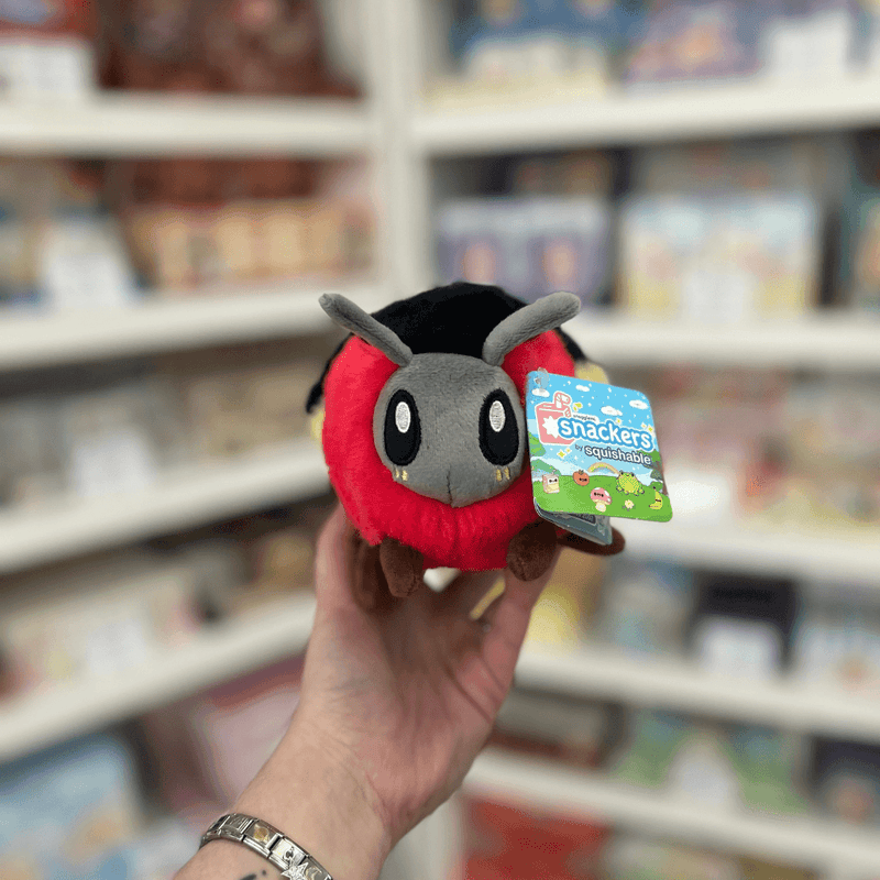 Squishable Snacker Firefly plush toy held in hand, front view with tag visible