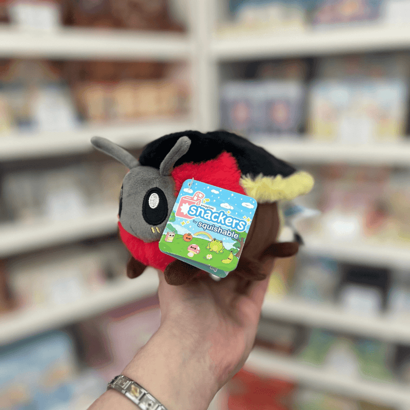 Squishable Snacker Firefly plush toy held in hand at an angle with tag visible