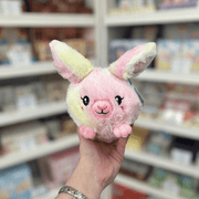Squishable Snacker Fluffy Bunny Tie Dye plush toy held in hand, front view