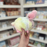 Squishable Snacker Fluffy Bunny Tie Dye plush toy held in hand, side view