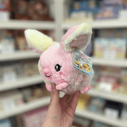 Squishable Snacker Fluffy Bunny Tie Dye plush toy held in hand with tag visible