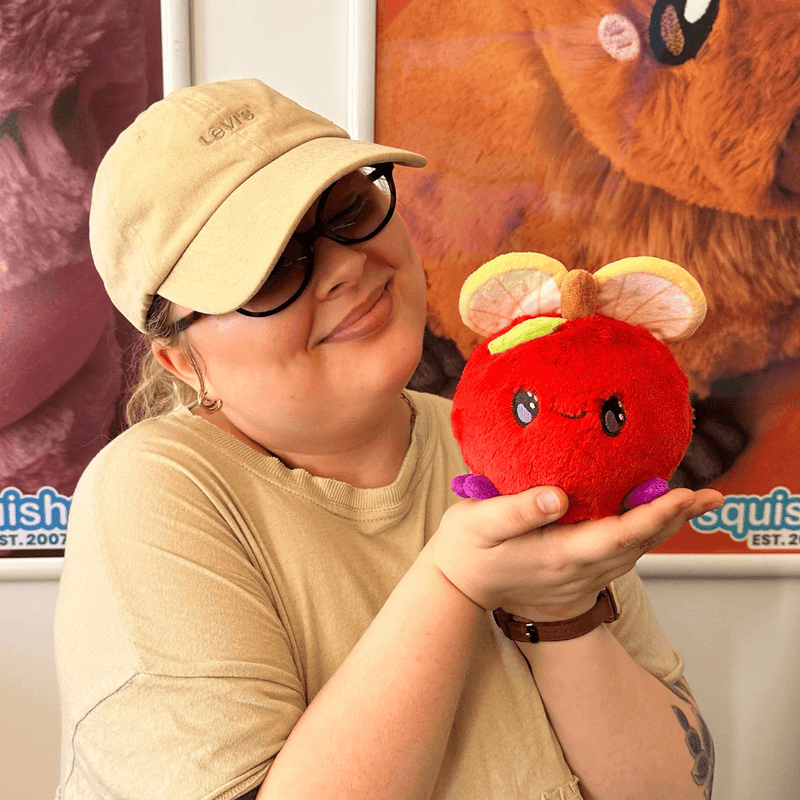 Person holding a Squishable Snacker Fruit Fly S1E3 plush toy