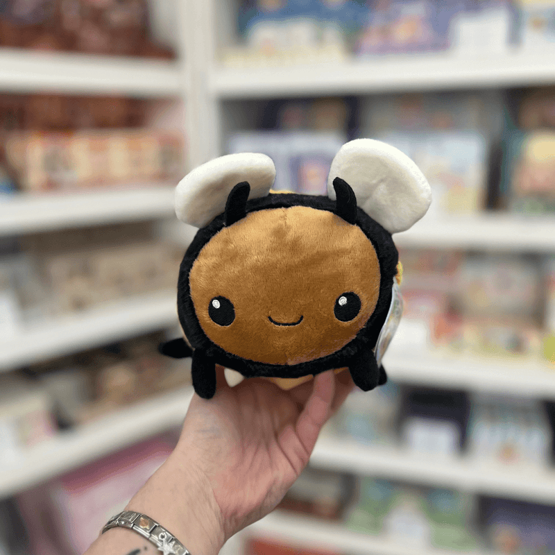 Squishable Snacker Fuzzy Bumblebee plush toy held in hand, front view