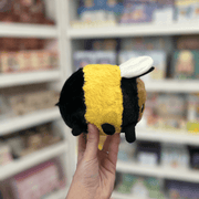 Squishable Snacker Fuzzy Bumblebee plush toy held in hand at an angle with tag visible