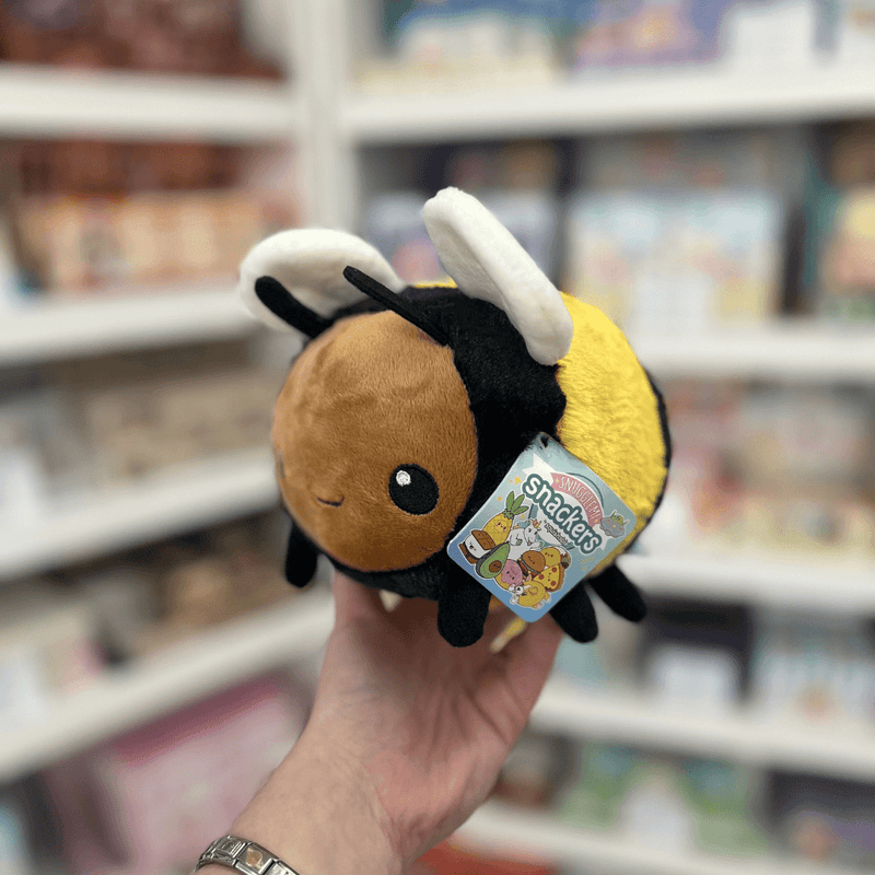 Squishable Snacker Fuzzy Bumblebee plush toy held in hand, side view