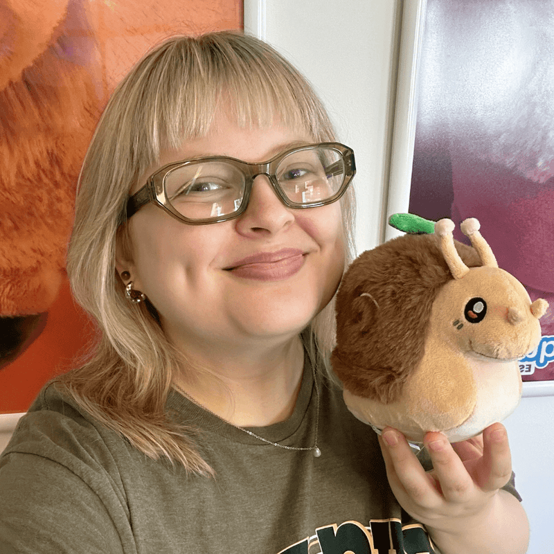 Person holding Squishable Snacker Garden Snail plush showing its small collectible size