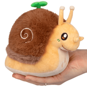 Squishable Snacker Garden Snail soft toy resting on a hand with fluffy brown shell
