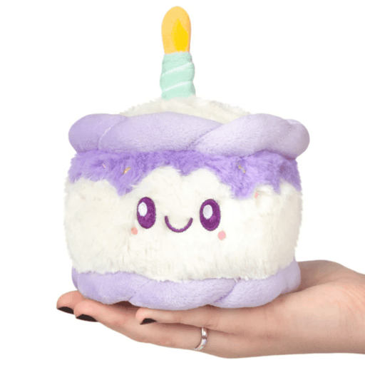 Front view of the Squishable Snacker Happy Birthday Cake plush toy with lilac frosting and candle detail