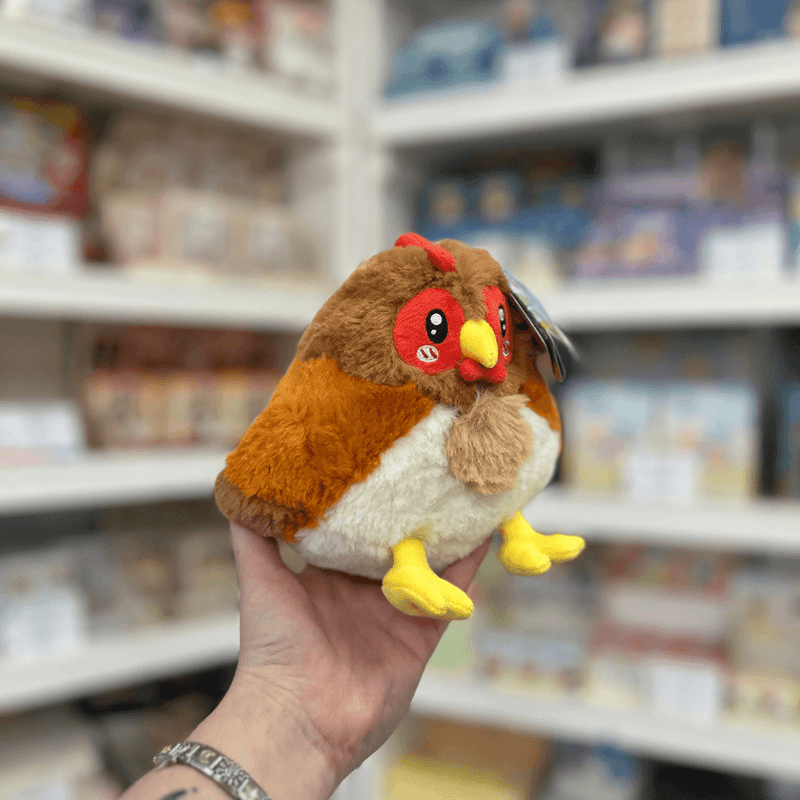 Squishable Snacker Hen plush toy angled view held in hand in a shop