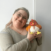 Person holding Squishable Snacker Hen plush toy for size reference
