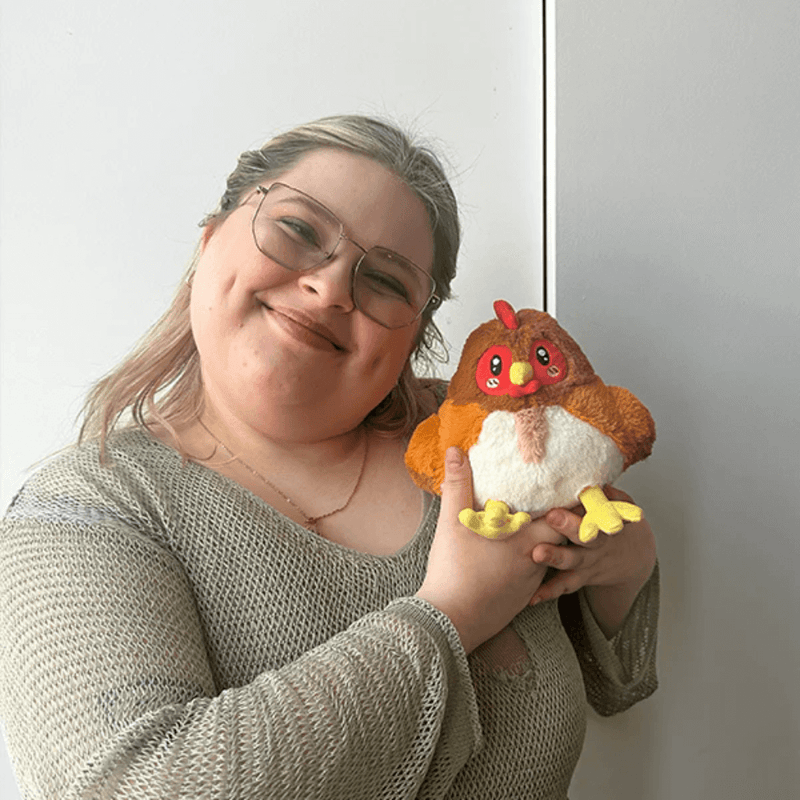 Person holding Squishable Snacker Hen plush toy for size reference
