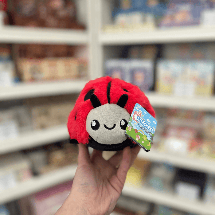 Squishable Snacker Ladybug plush toy held in hand, front view with tag visible