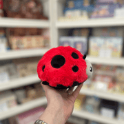 Squishable Snacker Ladybug plush toy held in hand, side view