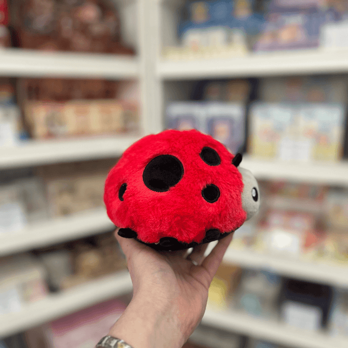 Squishable Snacker Ladybug plush toy held in hand, side view