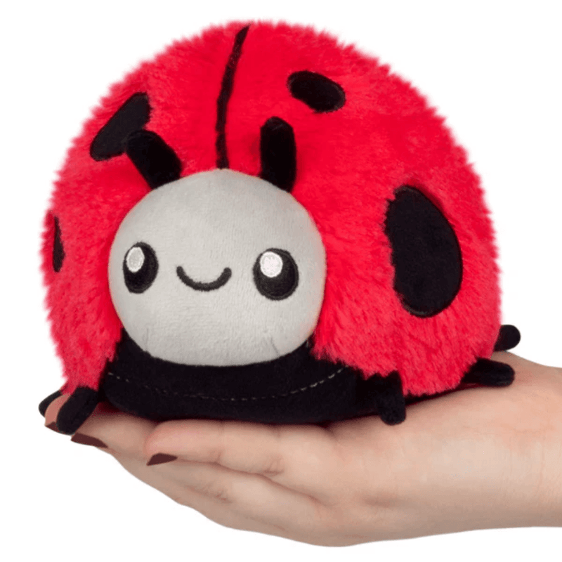 Squishable Snacker Ladybug plush toy sitting in a hand for size reference