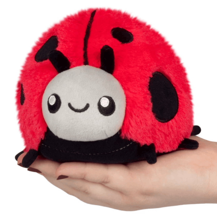 Squishable Snacker Ladybug plush toy sitting in a hand for size reference