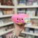 Squishable Snacker Pink Donut plush toy held in hand, front view