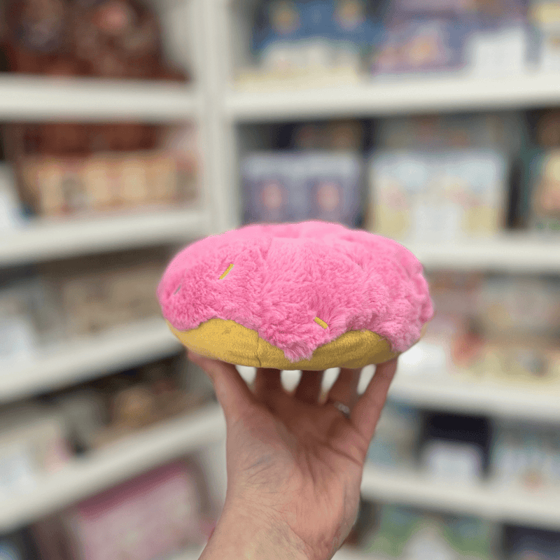 Squishable Snacker Pink Donut plush toy held in hand, side view