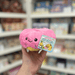 Squishable Snacker Pink Donut plush toy held in hand with tag visible