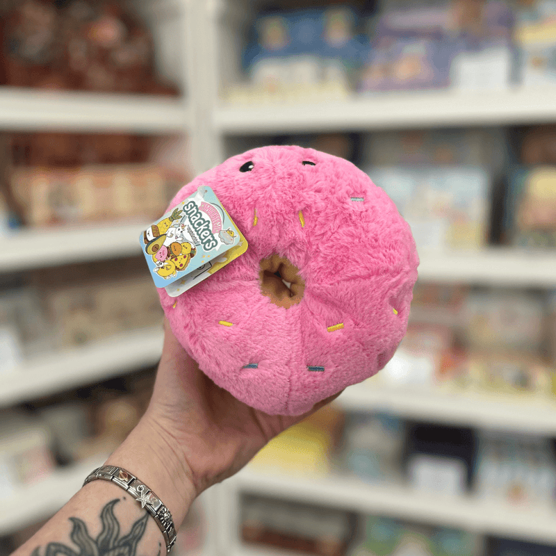 Squishable Snacker Pink Donut plush toy held in hand, top view
