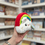 Squishable Snacker Rainbow plush toy angled view held in hand in a shop