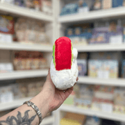 Squishable Snacker Rainbow plush toy side view held in hand in a shop