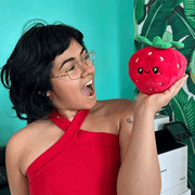 Person holding the Squishable Snacker Strawberry plush toy