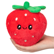 Squishable Snacker Strawberry plush toy held in a hand