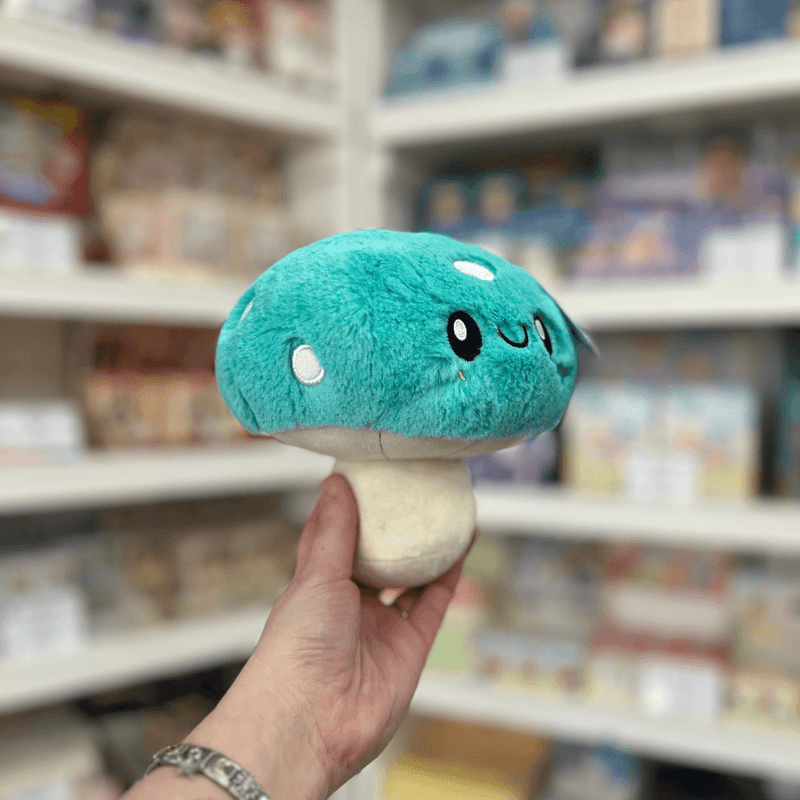 Squishable Snacker Turquoise Mushroom plush toy angled view held in hand in a shop
