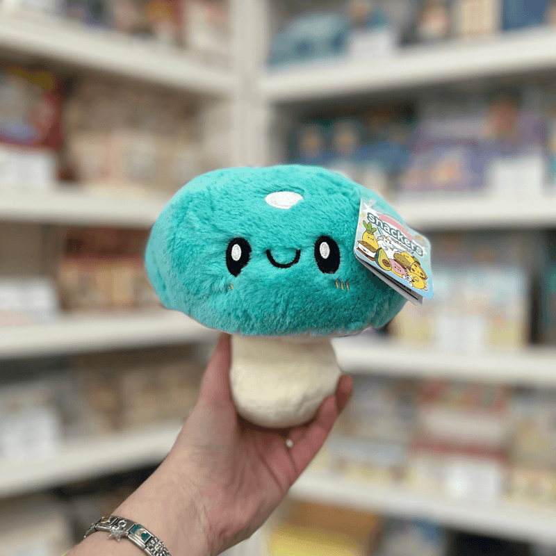 Squishable Snacker Turquoise Mushroom plush toy front view held in hand in a shop