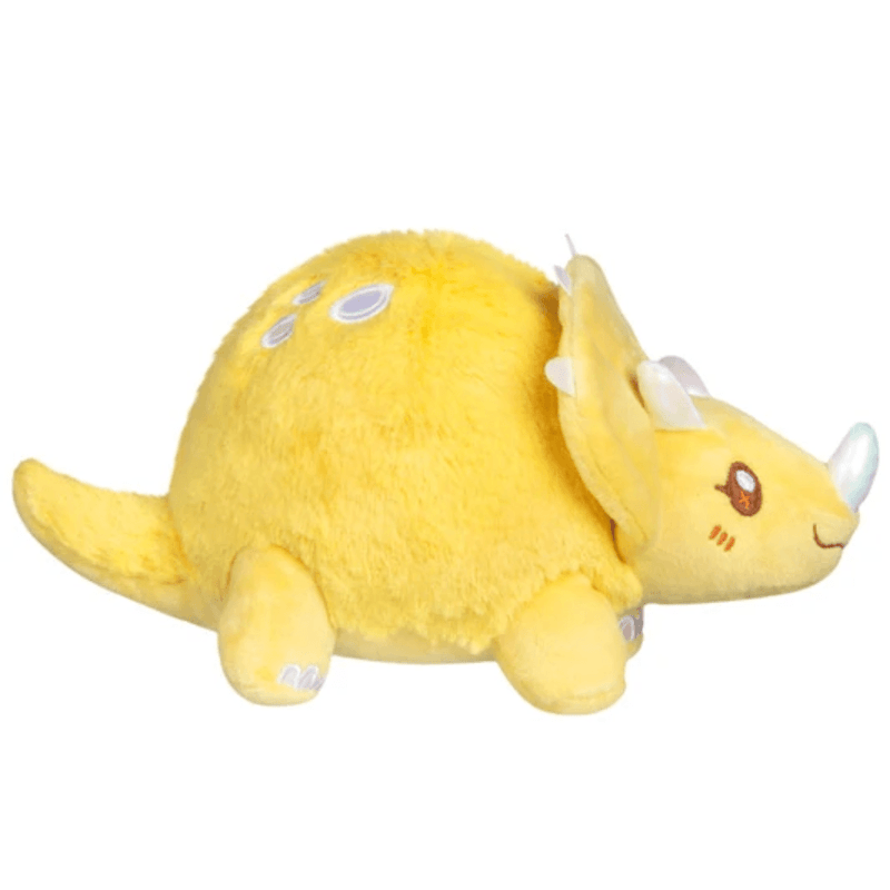Side view of the yellow Squishable Snacker Triceratops plush showing its tail