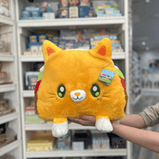 Squishable Taco Cat plush toy held in hands in a gift shop, front view