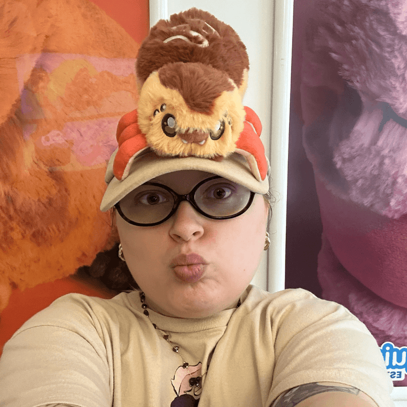 Person posing with the Squishable Alter Egos Takoyaki Spider plush toy