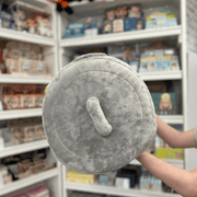 Squishable Trash Can plush toy held in hands in a gift shop, top view showing lid handle
