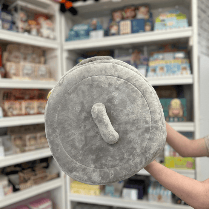 Squishable Trash Can plush toy held in hands in a gift shop, top view showing lid handle