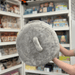 Squishable Trash Can plush toy held in hands in a gift shop, top view showing lid handle