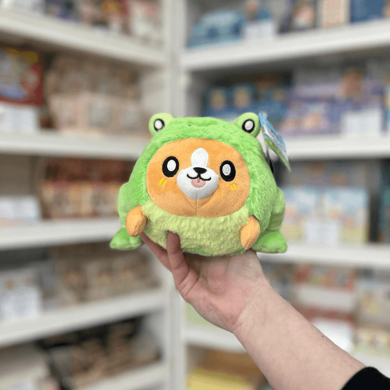 Squishable Undercover Snacker Corgi in Frog plush toy front view held in hand in a shop