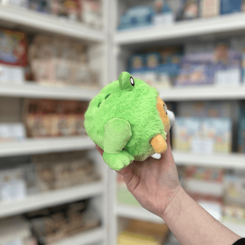Squishable Undercover Snacker Corgi in Frog plush toy side view held in hand in a shop