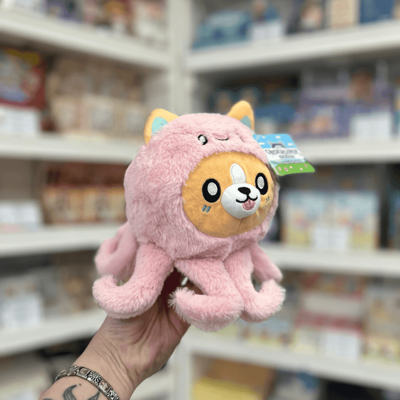 Squishable Undercover Snacker Corgi in Octopus plush toy angled view held in hand in a shop
