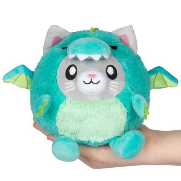 Squishable Undercover Snacker Kitty in Dragon plush in teal with wings and kitty face, held in hand