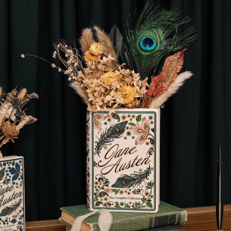 Jane Austen ceramic book vase displayed with dried flowers and a peacock feather